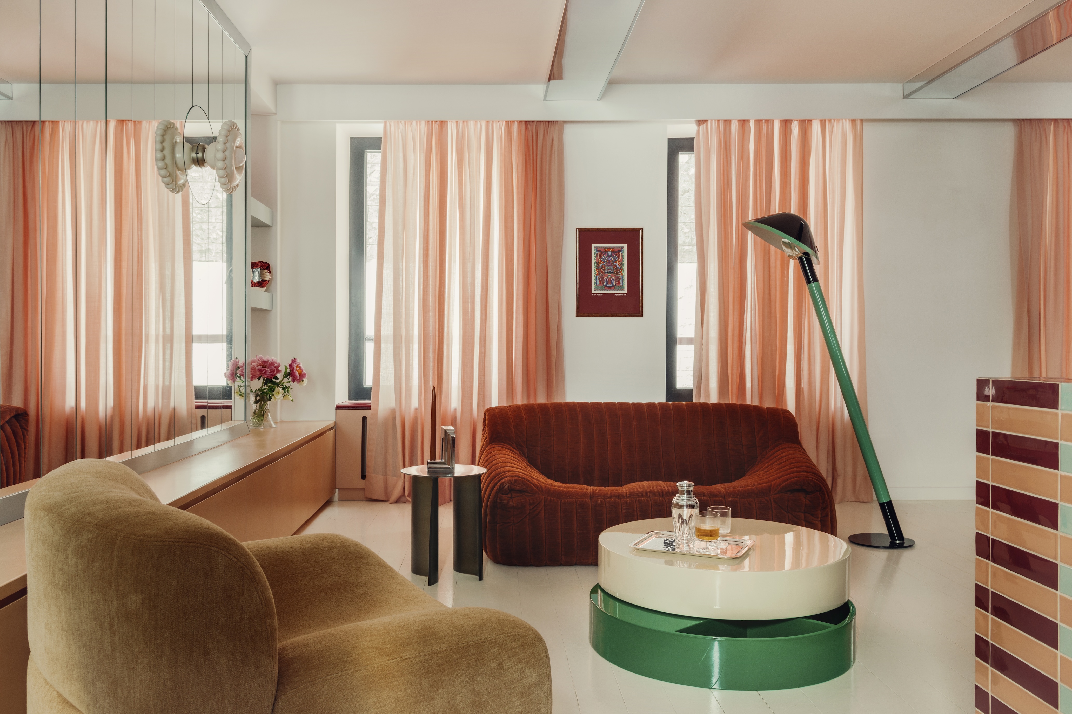 Sheer salmon-colored curtains soften the light across a living room interior full of glossy surfaces.