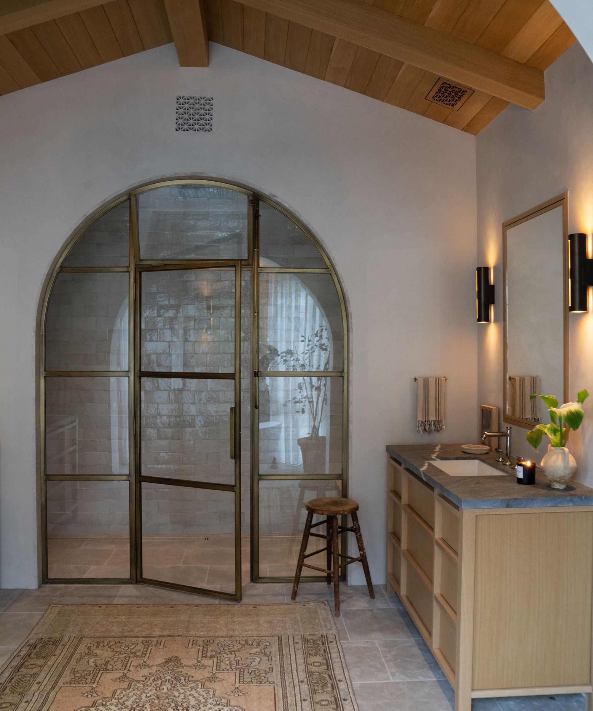 bathroom with arched brass door to shower