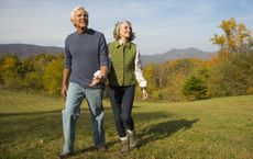 Older couple walking in field