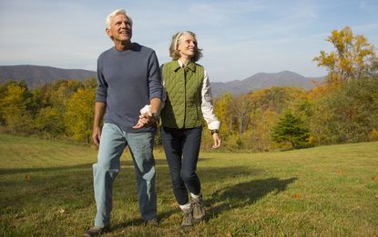 Older couple walking in field