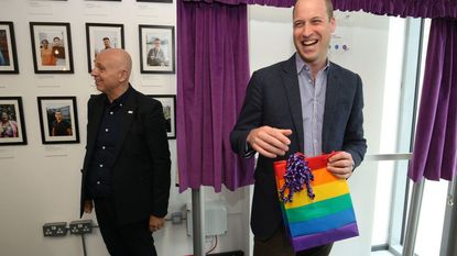 Britain's Prince William, Duke of Cambridge, reacts to receiving a gift bag from trust chief executive officer Tim Sigsworth during a visit to the Albert Kennedy Trust in London to learn about the issue of LGBTQ youth homelessness in London on June 26, 2019.