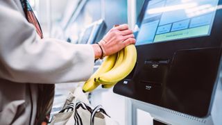 A woman scanning bananas at a self-checkout