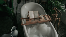 Book in bubble bath surrounded by plants.