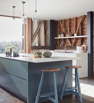 rustic kitchen with blue island and wooden beams