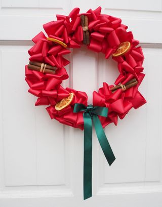 Christmas red and green ribbon wreath on white door