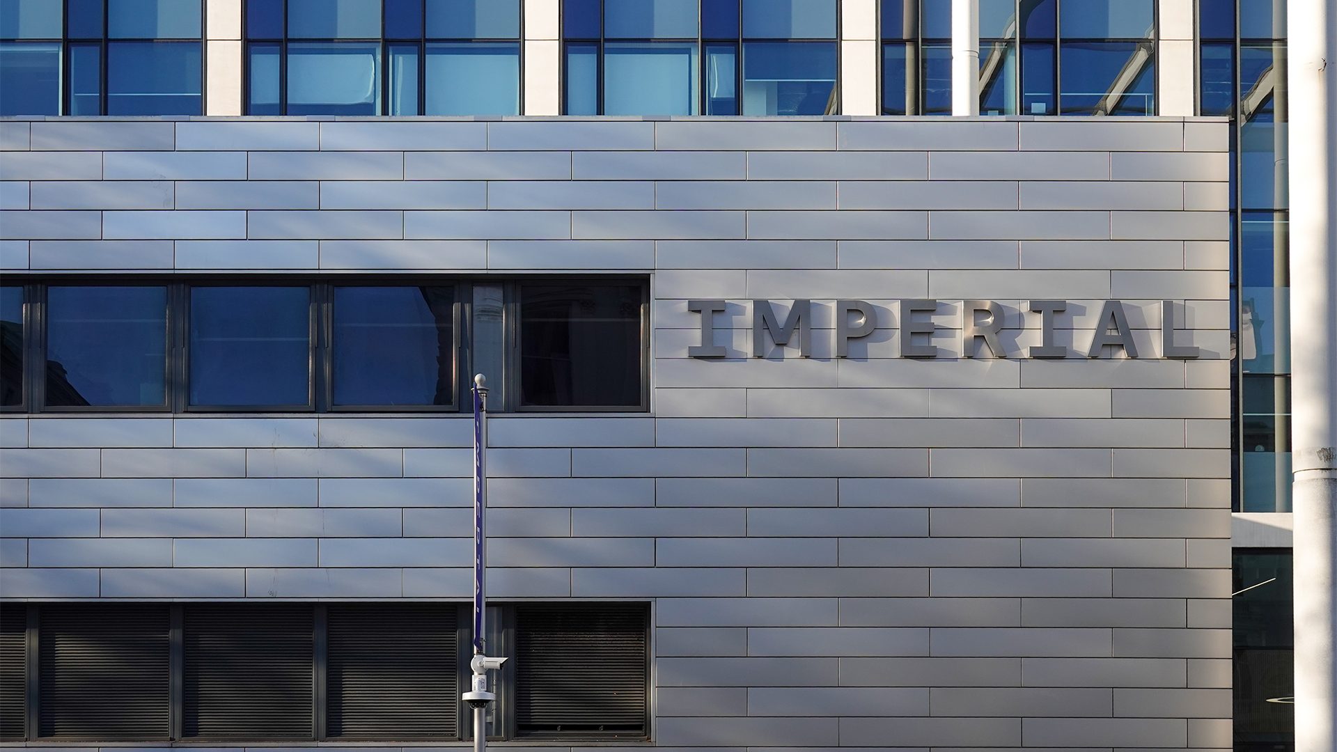 Imperial London College South Kensington campus pictured during daylight with 'Imperial' emblazoned on side of building.