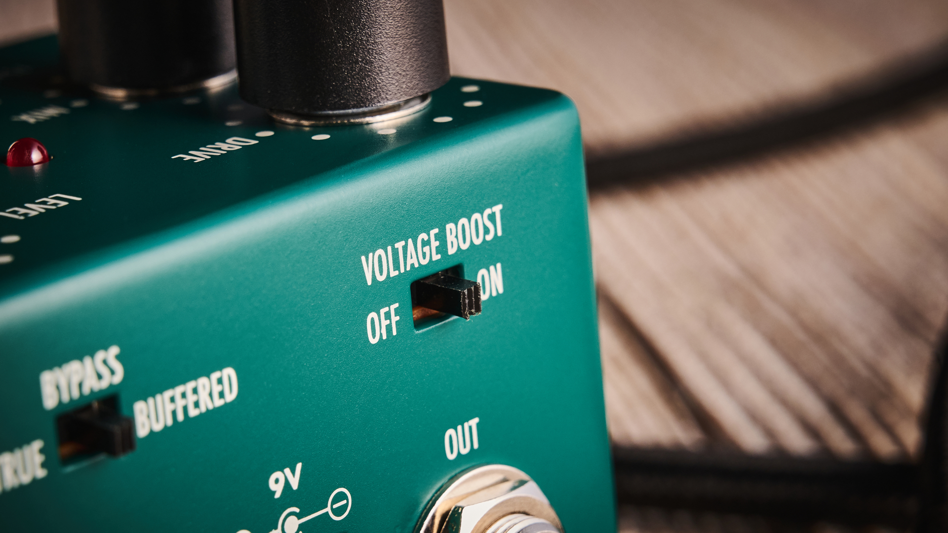 Warm Audio Tube Squealer green overdrive pedal shot on wood floorboards
