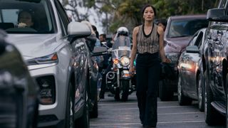 Cate standing on a road surrounded by traffic in Monarch: Legacy of Monsters season 2 episode 4