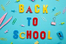 "back to school" spelled in colorful lettering against a bright blue background with various school supplies