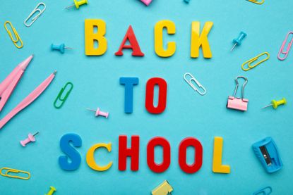 "back to school" spelled in colorful lettering against a bright blue background with various school supplies