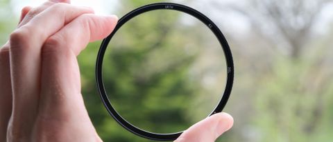 UV lens filter held between two fingers