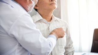 A doctor listens to a patient's lungs with a stethoscope.