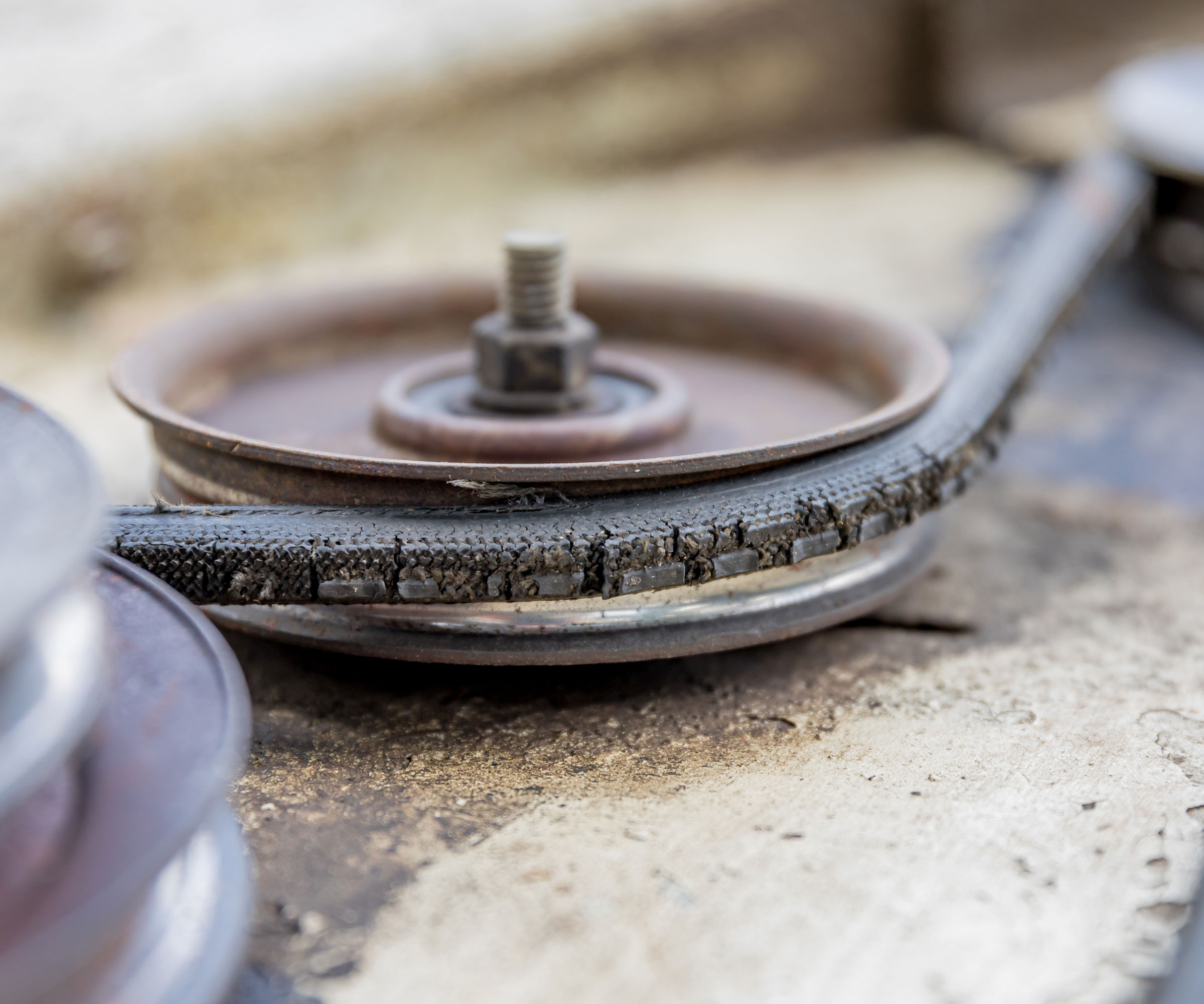 lawn mower belt in detail showing signs of wear and tear