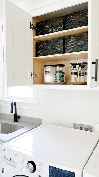 Laundry room wall cabinet with transparent storage jars and baskets