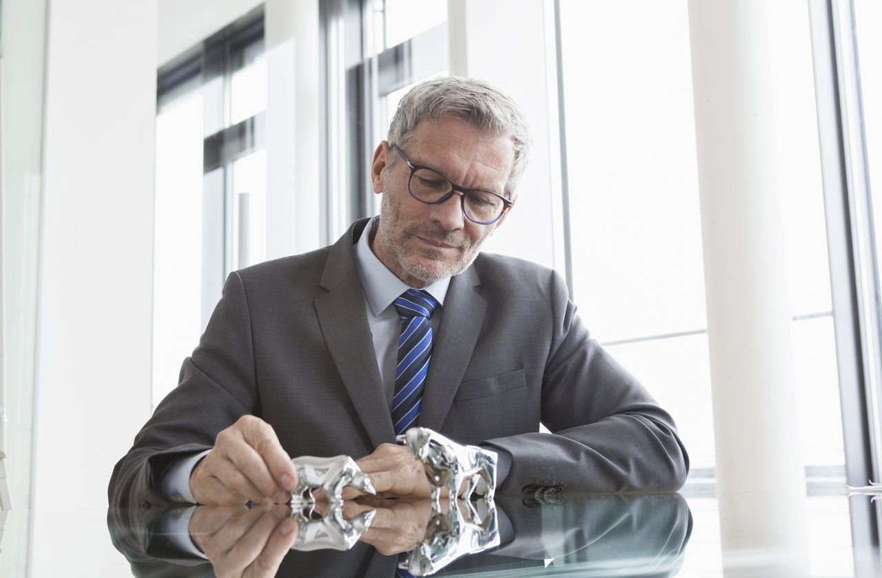 Businessman observing stock market, bull and bear figurines