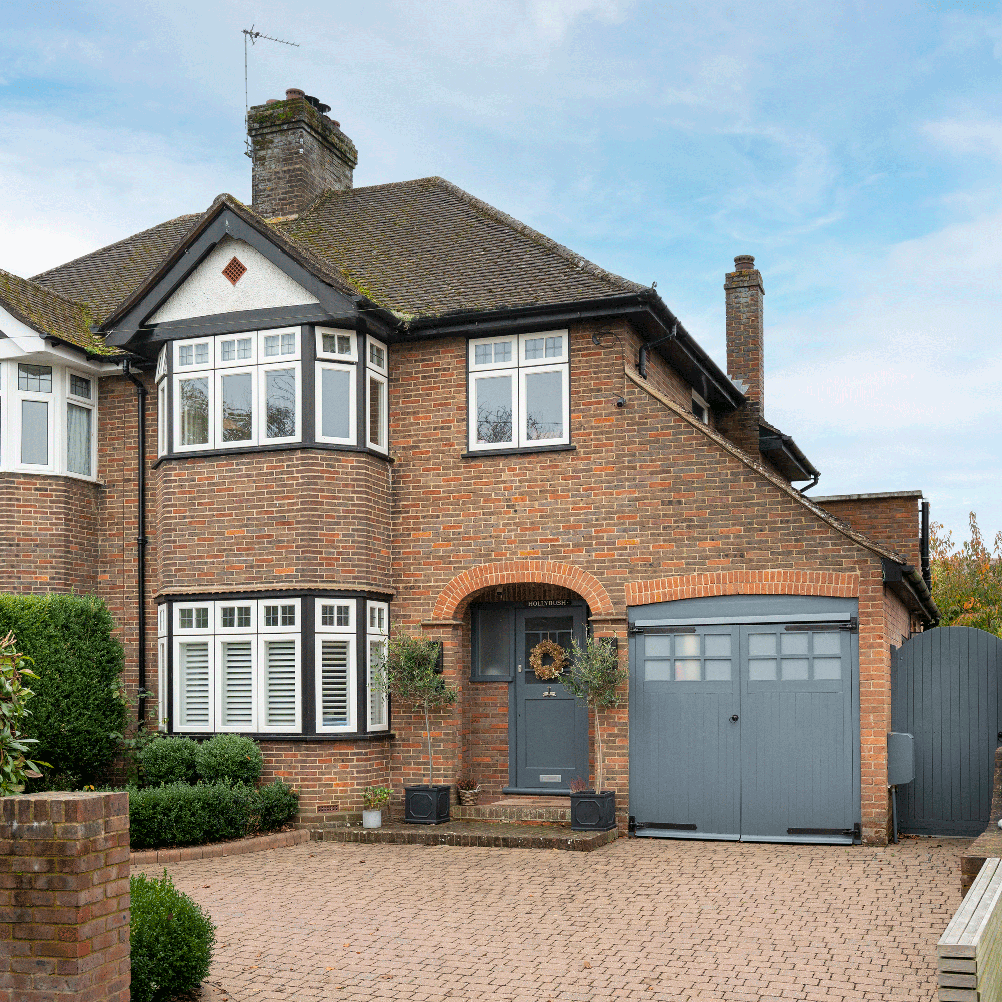 the exterior of a 1930s house with a garage on the side