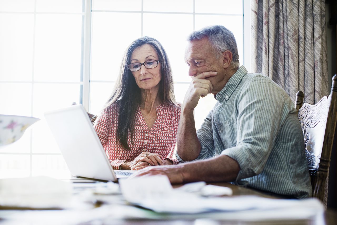 Two pensioners looking puzzled at a laptop