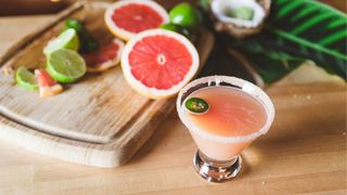 Grapefruit juice in glass with salt on the rim and jalapeno as garnish