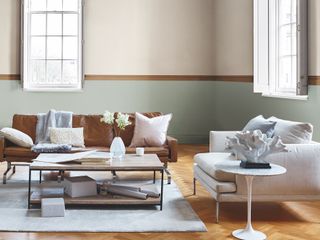 bright living room with a painted stripe, brown leather sofa and wooden coffee table