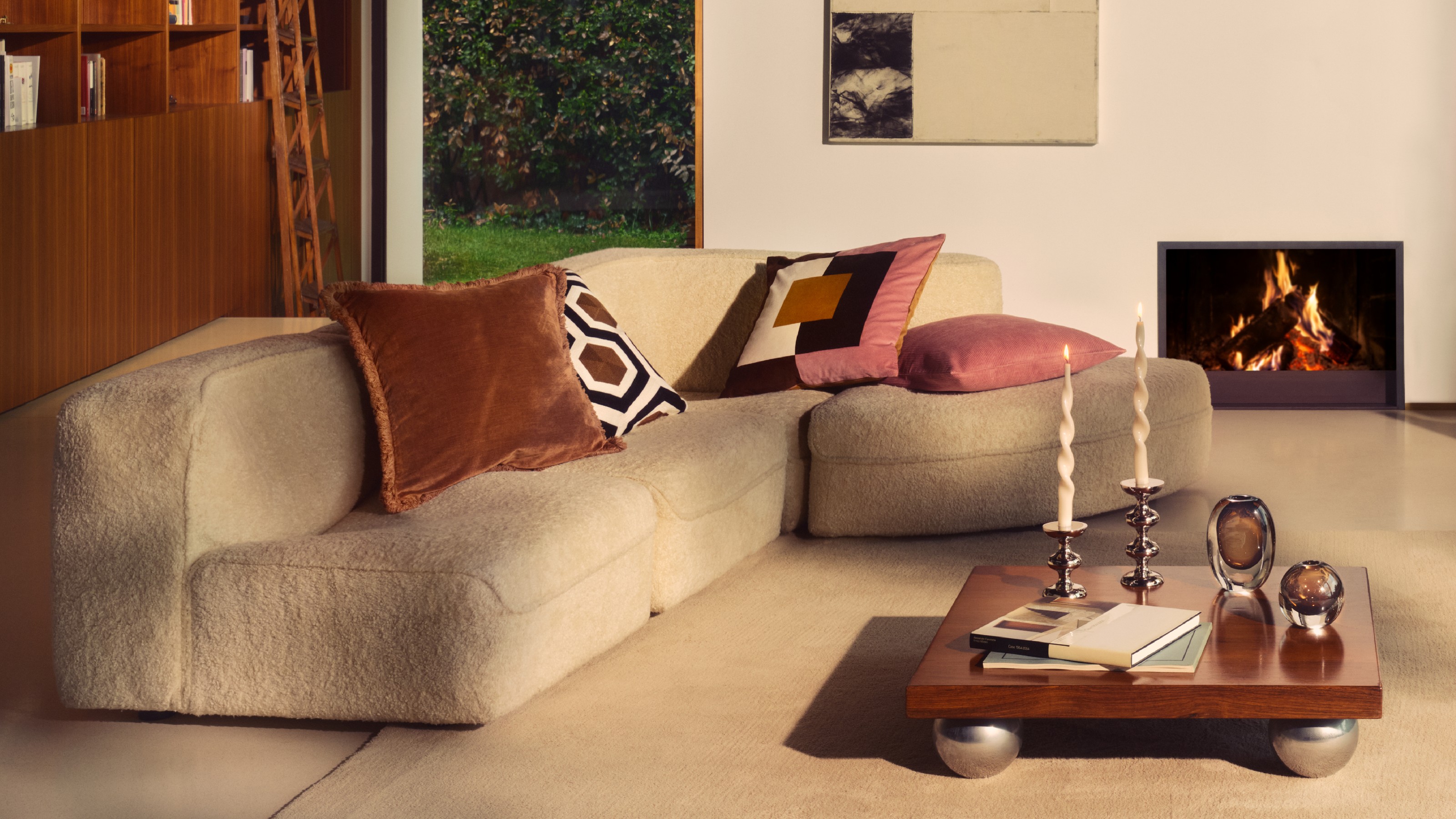 A living room with a modular sofa decorated with patterned cushions from the H&amp;M Home autumn 2025 collection