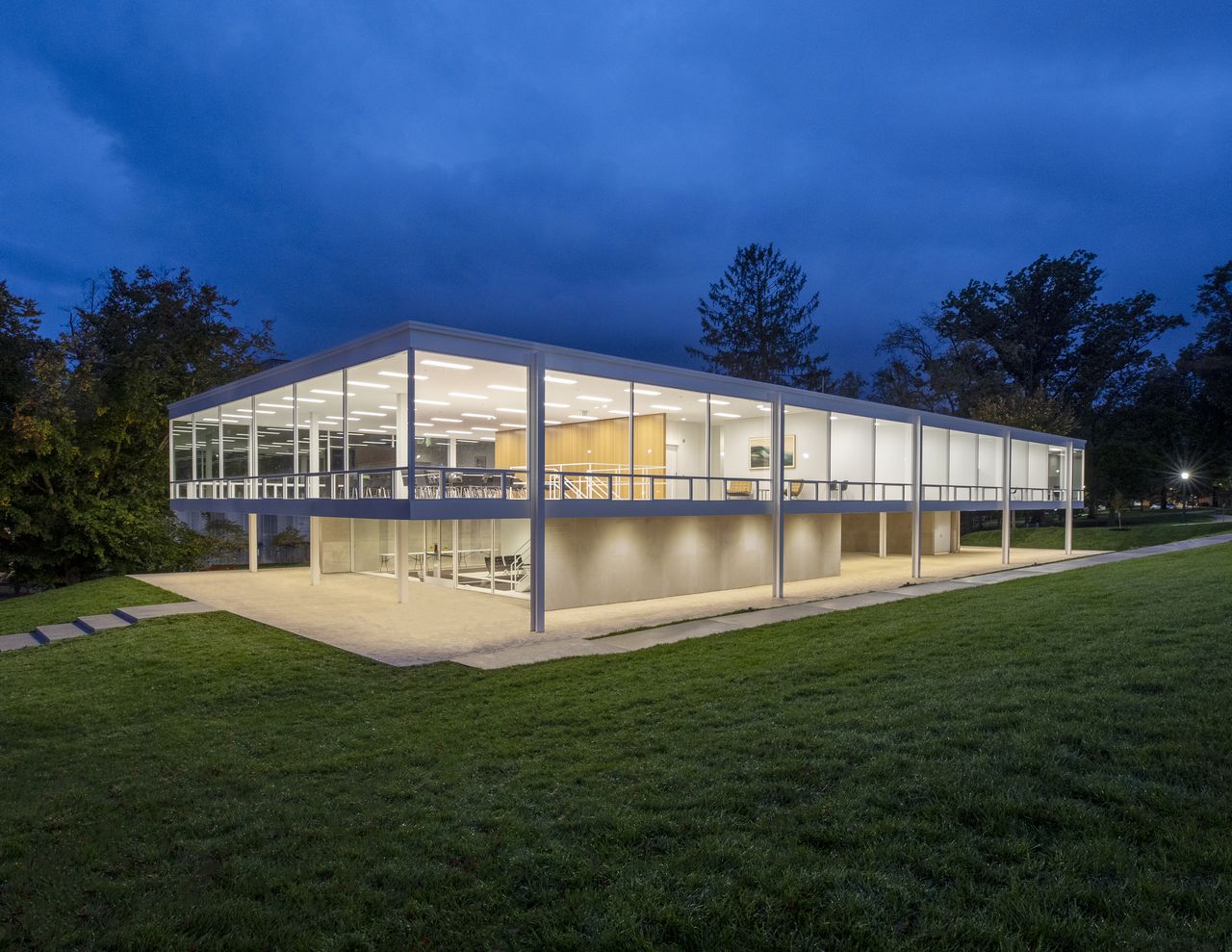 A night view of the double storey Eskenazi School of Art with a green lawn in front of it.