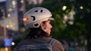 Bern helmet being worn by a woman with medium length dark hair at night
