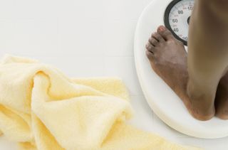 A woman on the scales weighing herself whilst on the Dukan diet