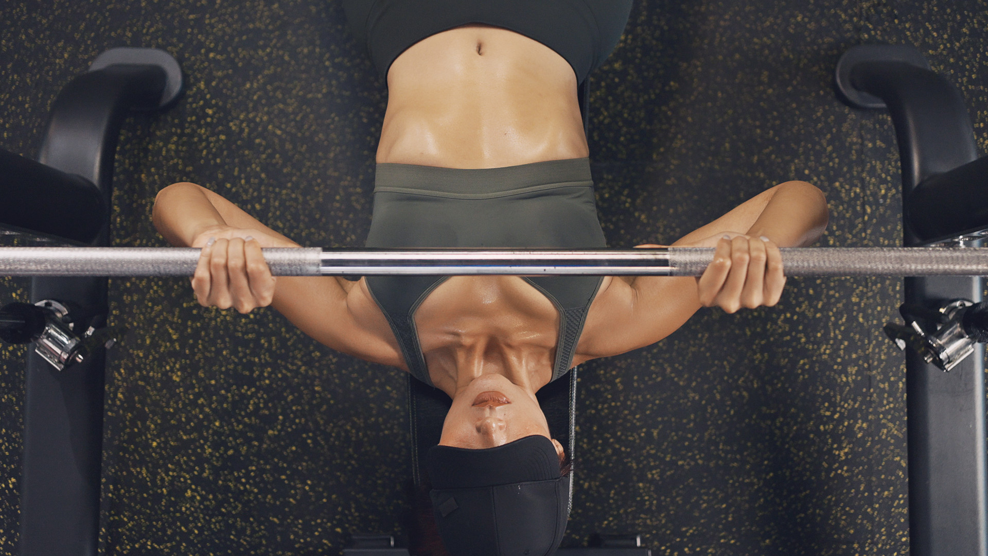 A woman performing the JM press on a weight bench