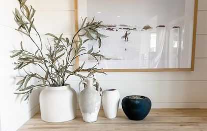 DIY ceramic vases on table with olive branches, more pots and a frame