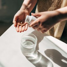 person putting supplements into their hand ready to take