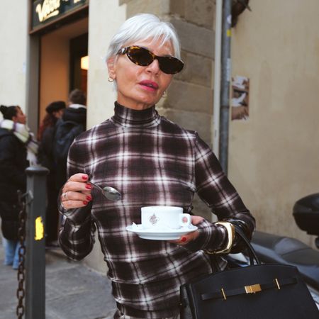 A woman drinks coffee outside