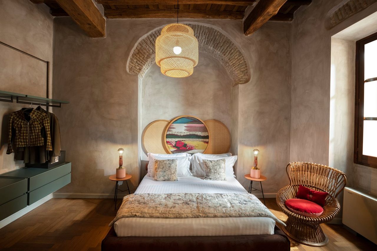 A modern rustic-meets-glamour hotel in Rome features cement, wood, and brick walls and eccentric decorations.