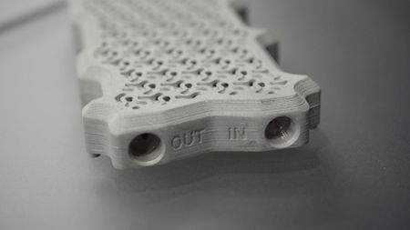 A photo of a custom cold plate for an Nvidia H100, designed and manufactured by Alloy Enterprises, after modelling the optimal fluid flow by nTop