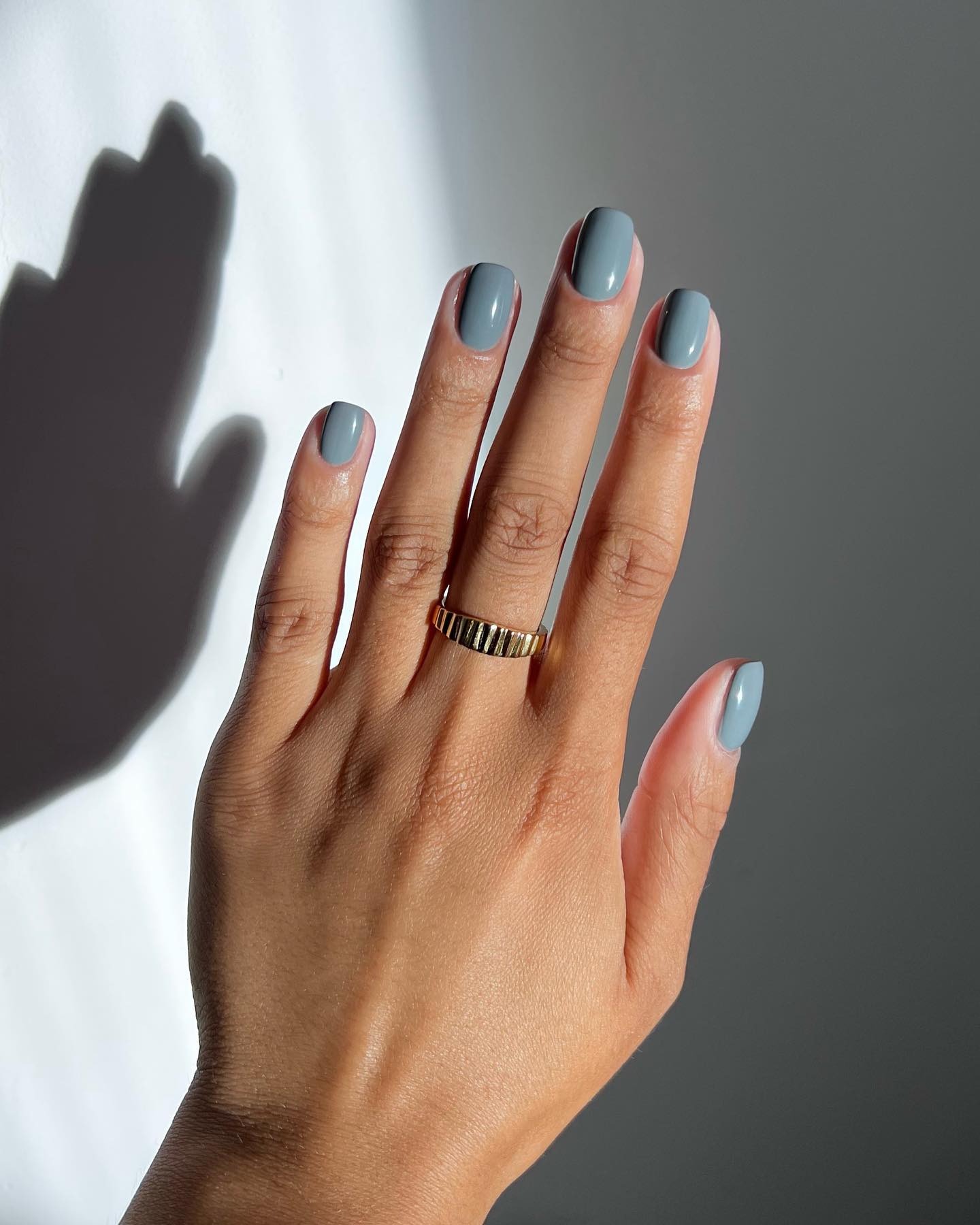A close-up of a blue-ish grey manicure
