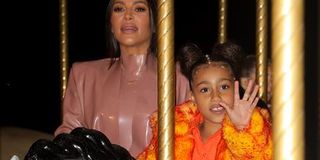 Kim Kardashian and daughter North West riding a fairground carousel