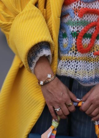 Woman wearing a mixture of gold and silver bracelets