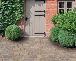 front garden design with permeable cobblestones and shrubs