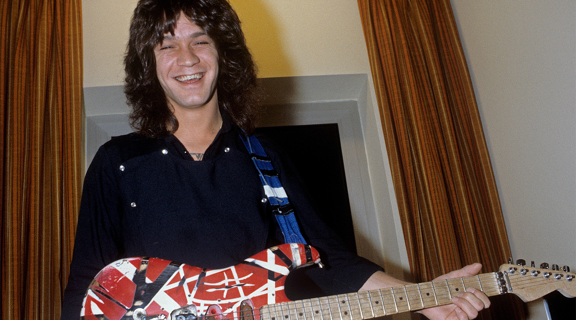 Eddie Van Halen stands holding his Frankenstein guitar in October 1981