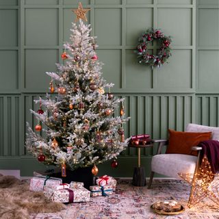 Green panelled living room with rosted woodland Christmas tree