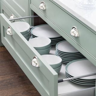 light blue drawers with plates and bowls and white counter