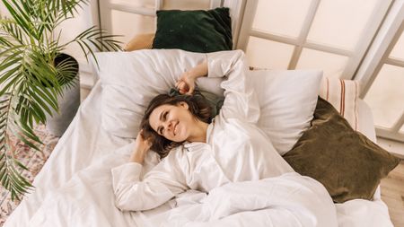 Woman wakes up happy after a great night's sleep on her new mattress