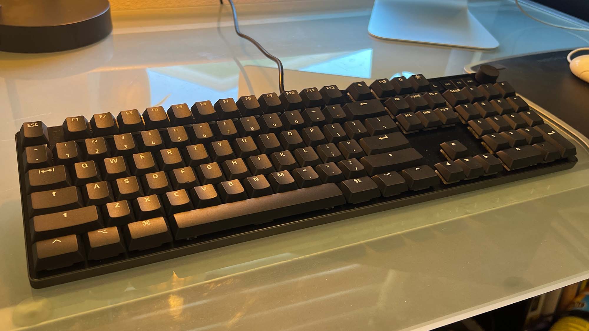 A Das Keyboard MacTigr on a glass-top desk