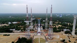 wide shot of a white rocket on the launch pad, surrounded by four tall lightning towers