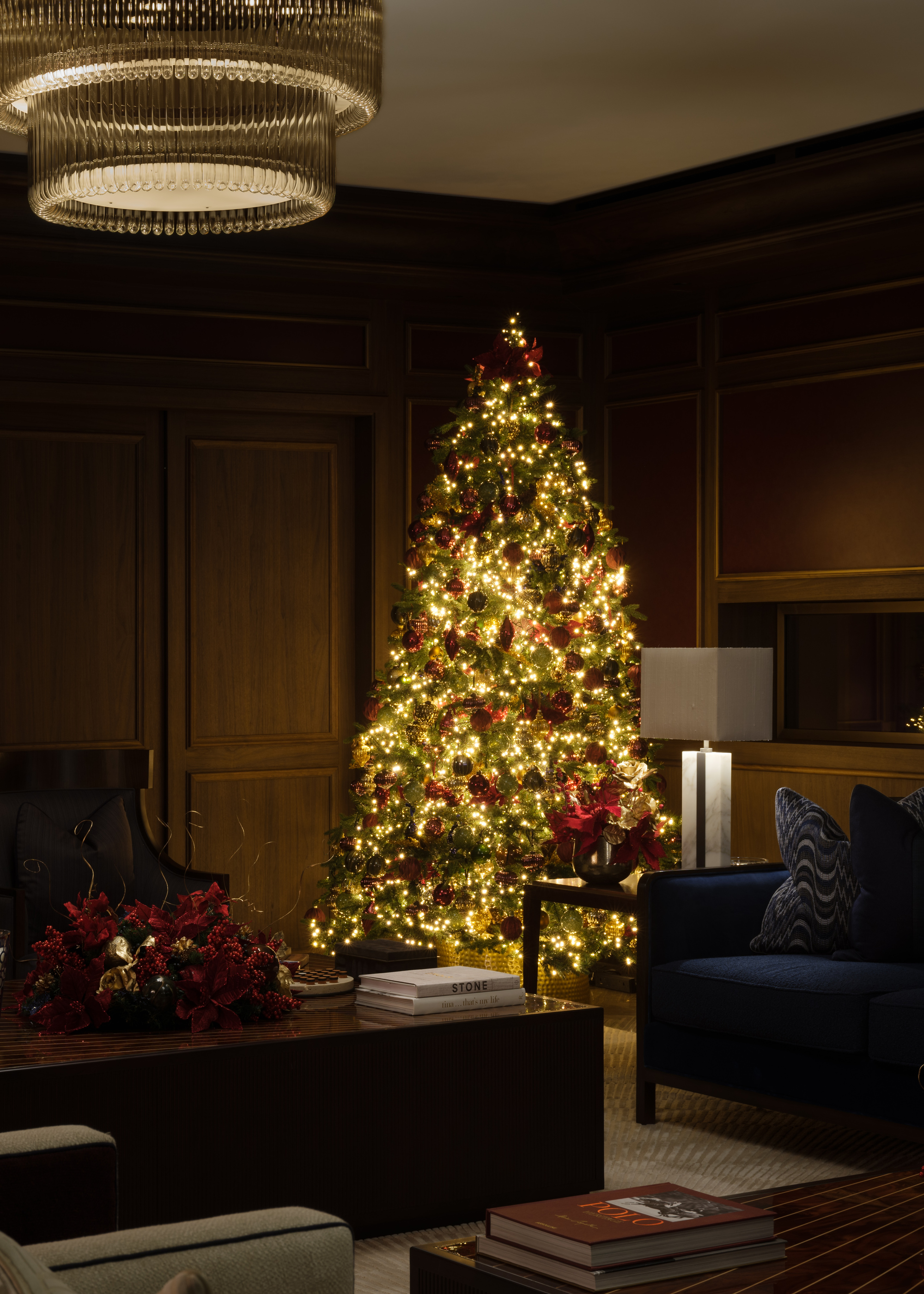 A dimly lit living room decorated for Christmas with cluster lights and traditional ornaments