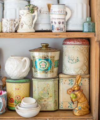 collection of vintage storage tins and ceramic ware on a shelf