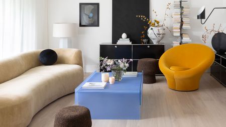 a living room with a bright blue coffee table and yellow chair