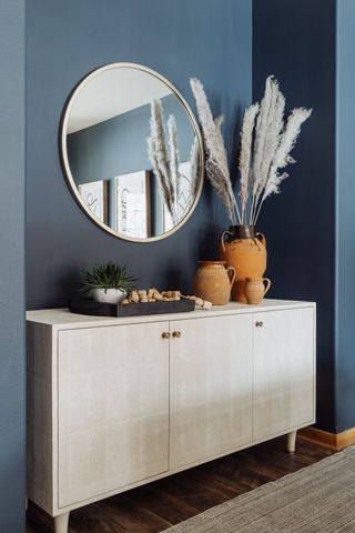 A credenza with vases and feathered stems