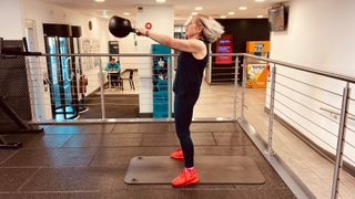 Joanne Mallon lifting kettlebell into the air at the gym, representing how to start weightlifting