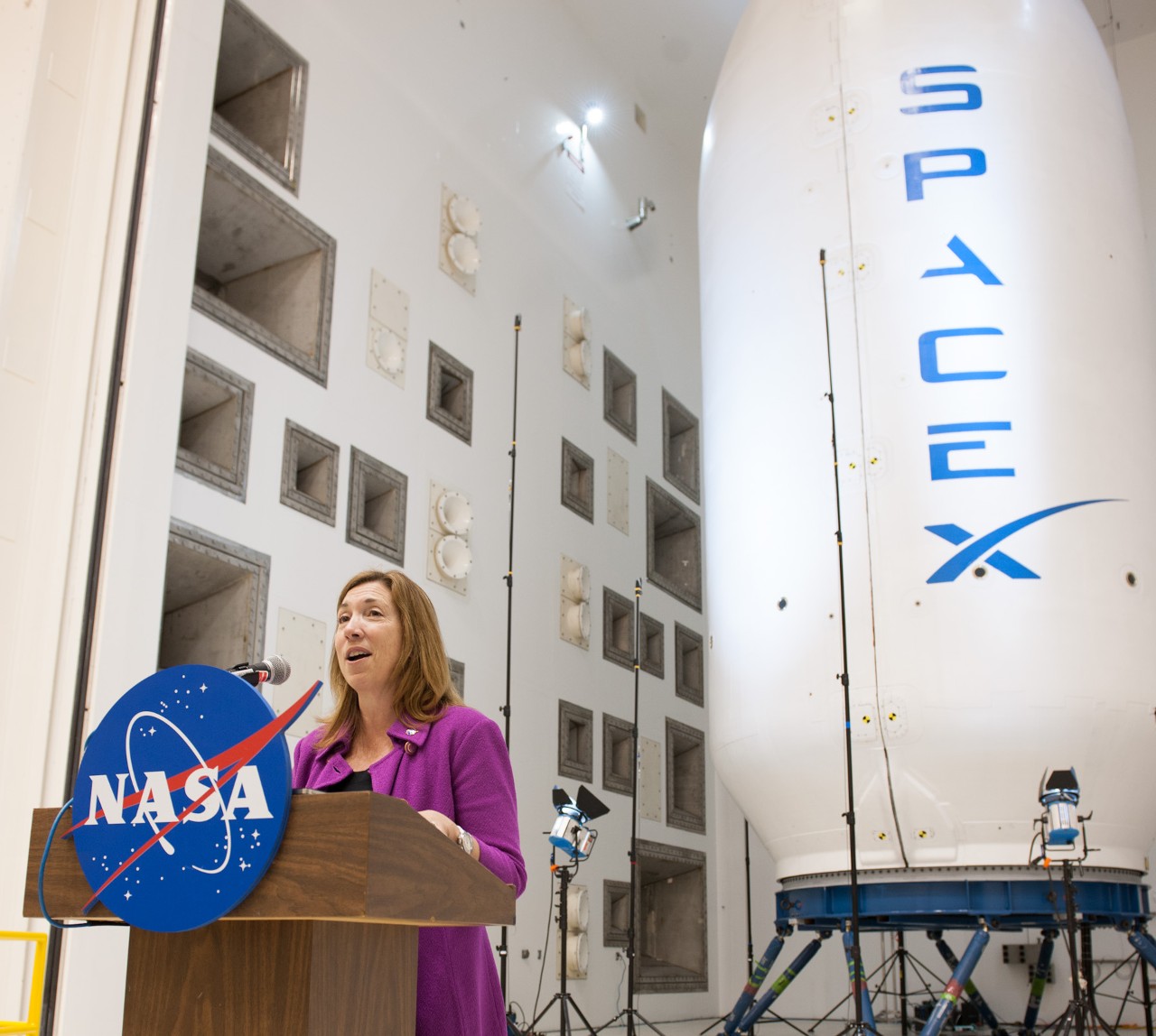 NASA Deputy Administrator Lori Garver holds a media briefing in the new Reverberant Acoustic Test Facility at NASA Glenn in front of a SpaceX Falcon 9 fairing.