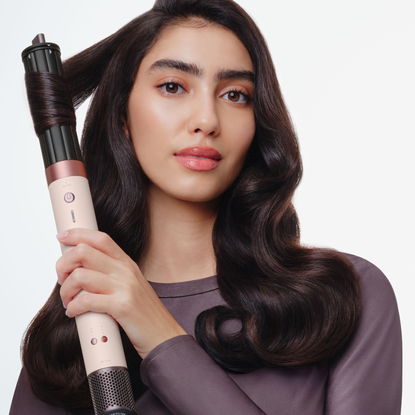 Model with sleek blow-out using the Dyson Airwrap in rose